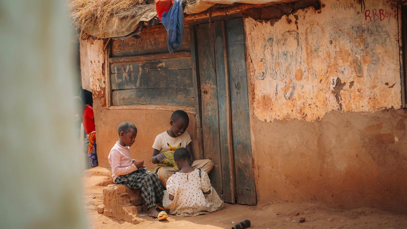 Children sitting outside a house in Dzaleka
