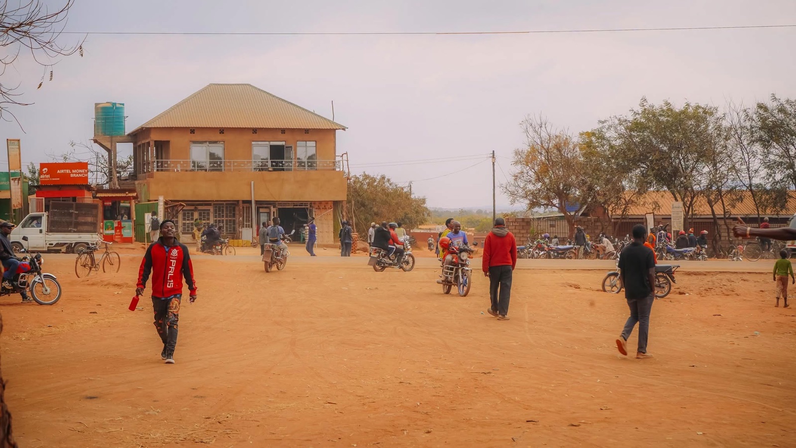 People and motorcycles on a commercial road in Dzaleka