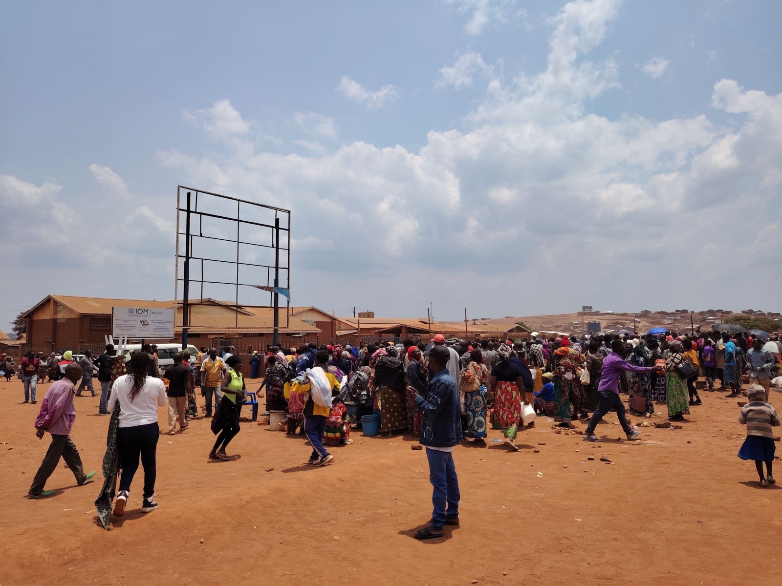 A large community gathering in an open area at Dzaleka