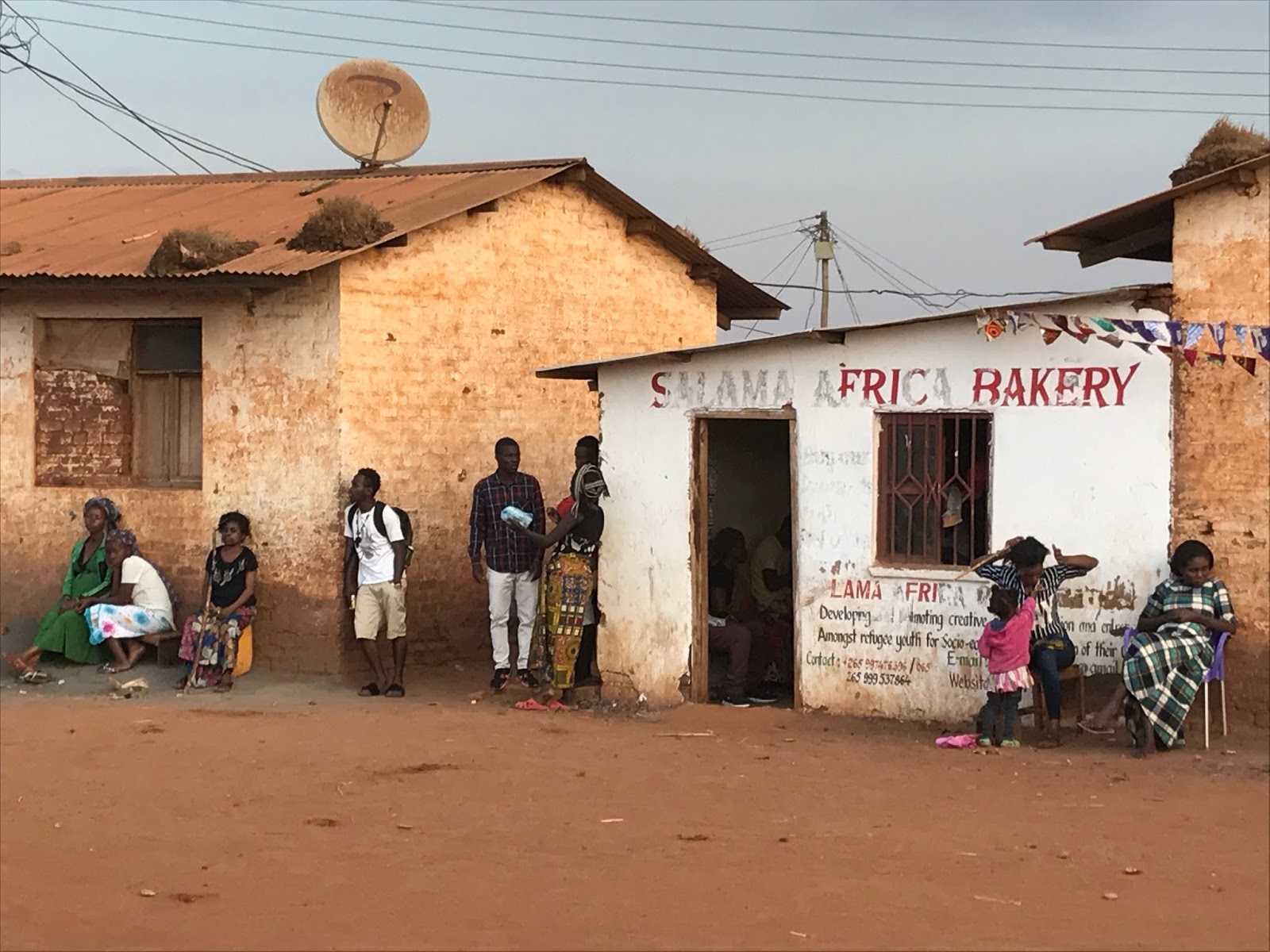 A bakery storefront inside Dzaleka, one of the ordinary places that keeps the article from becoming only a festival diary.