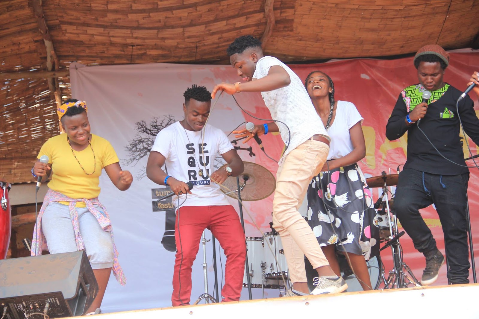 Performers crowd the stage during Tumaini Festival, with the audience pressed close to the front.